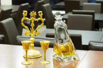 a bottle of whiskey and two glasses on a table at Hotel Sterling Garni in Belgrade