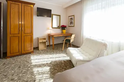 a living room with a white couch and a table at Hotel Sterling Garni in Belgrade
