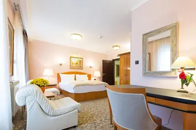 a hotel room with a bed and a desk at Hotel Sterling Garni in Belgrade