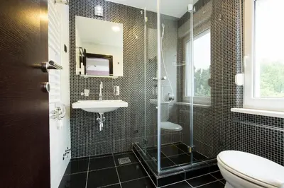 a bathroom with a shower and a sink and a toilet at Hotel Sterling Garni in Belgrade