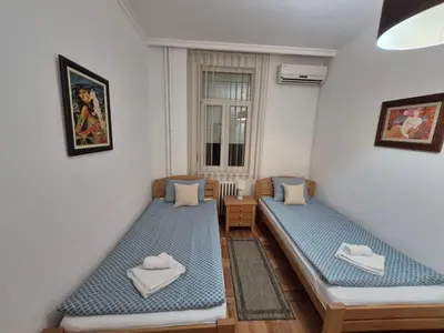 a room with two beds and a window at Authentic Belgrade Centre Apartment #5, Four bedrooms, One Full Bathroom, One Toilet in Belgrade