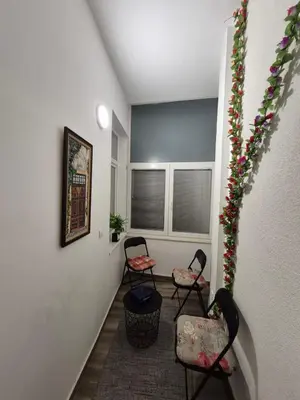 a hallway with two chairs and flowers on the wall at Authentic Belgrade Centre Apartment #5, Four bedrooms, One Full Bathroom, One Toilet in Belgrade