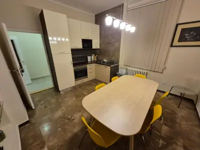 a kitchen with a wooden table and yellow chairs at Authentic Belgrade Centre Apartment #5, Four bedrooms, One Full Bathroom, One Toilet in Belgrade