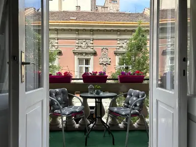 a balcony with a table and chairs and a building at Princ Apartment in Belgrade
