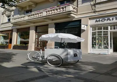 a bike with an umbrella in front of a store at Princ Apartment in Belgrade