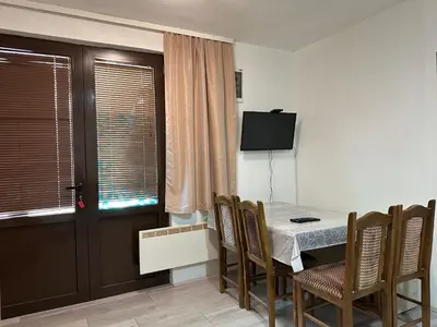 a dining room with a table and chairs and a television at Apartman Centar BB in Pančevo