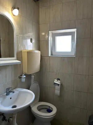 a bathroom with a sink and a toilet and a window at Apartman Centar BB in Pančevo