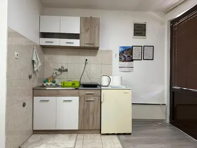 a kitchen with white cabinets and a white refrigerator at Apartman Centar BB in Pančevo