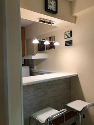 a bar in a kitchen with two stools and a clock at AMN Center Apartment in Belgrade