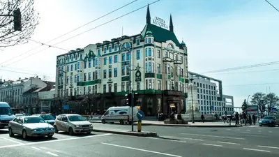 a large building on a busy city street with cars at AMN Center Apartment in Belgrade
