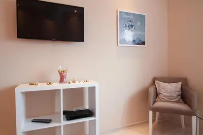 a living room with a tv and a chair at Savamala Lux Apartment in Belgrade