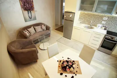 a kitchen and living room with a couch and a table at Savamala Lux Apartment in Belgrade