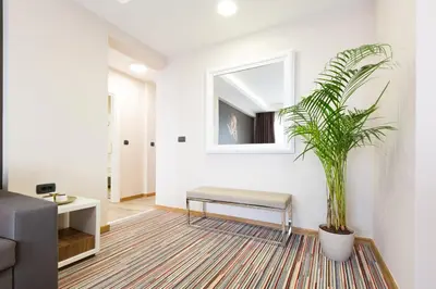 a living room with a bench and a plant at Hotel TESLA - Smart Stay Garni in Belgrade