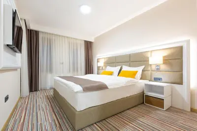a hotel room with a large bed and a television at Hotel TESLA - Smart Stay Garni in Belgrade