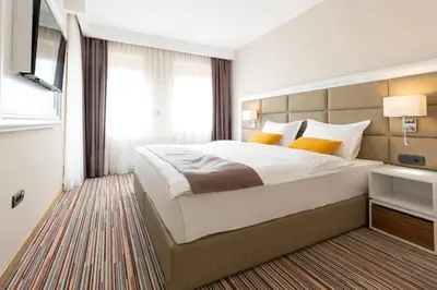 a bedroom with a large white bed and a window at Hotel TESLA - Smart Stay Garni in Belgrade