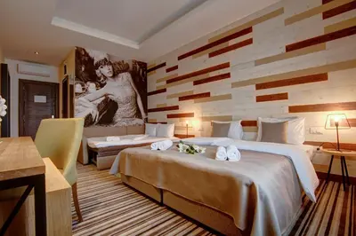 a hotel room with two beds and a painting on the wall at Hotel Zavicaj in Belgrade