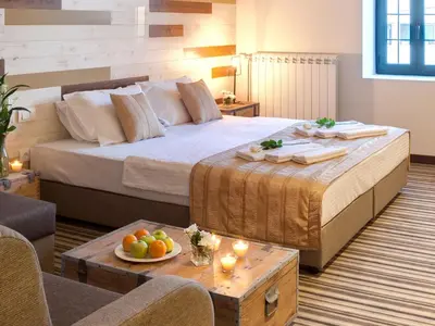 a bedroom with a large bed with a table with fruit on it at Hotel Zavicaj in Belgrade