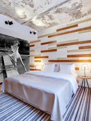 a bedroom with a white bed and a wall with wood at Hotel Zavicaj in Belgrade