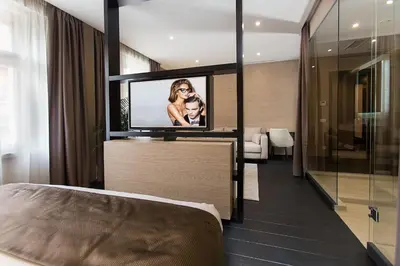 a hotel room with a tv and a bed at Dominic Smart & Luxury Suites - Republic Square in Belgrade