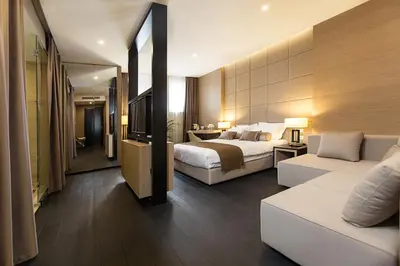 a hotel room with a bed and a couch at Dominic Smart & Luxury Suites - Republic Square in Belgrade