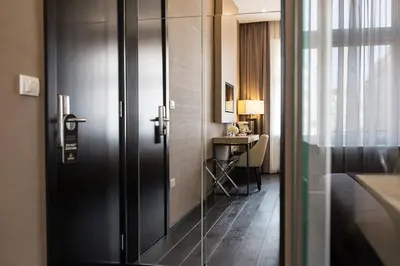a door leading to a room with a desk and a bed at Dominic Smart & Luxury Suites - Republic Square in Belgrade