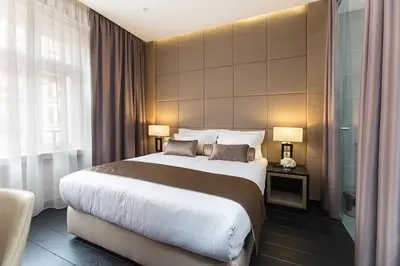 a hotel room with a large bed and two lamps at Dominic Smart & Luxury Suites - Republic Square in Belgrade