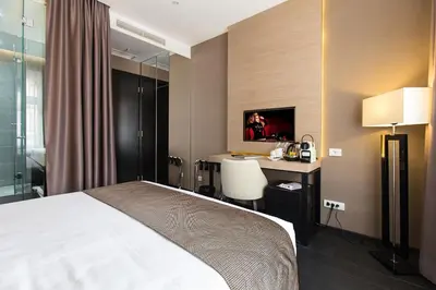 a hotel room with a bed and a desk at Dominic Smart & Luxury Suites - Republic Square in Belgrade