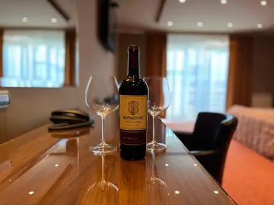 a bottle of wine sitting on a table with two glasses at Vila Srbija Beograd in Meljak