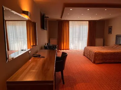a hotel room with a bed and a desk in a room at Vila Srbija Beograd in Meljak