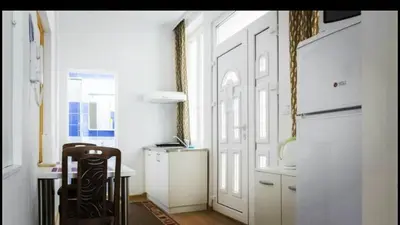 a kitchen with a table and a chair and a door at Beograd Admiral Apartments in Belgrade