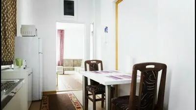 a kitchen with a table and two chairs and a refrigerator at Beograd Admiral Apartments in Belgrade