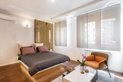 a bedroom with a bed and a chair at Leo Modern Urban Stay, Self Check-In, Free Garage in Belgrade