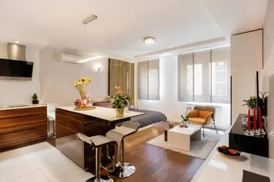 a bedroom with a bed and a kitchen and a living room at Leo Modern Urban Stay, Self Check-In, Free Garage in Belgrade