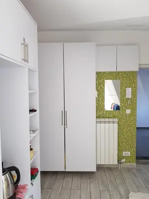 a kitchen with white cabinets and a mirror at Apartment Sovica in Belgrade