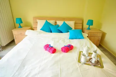 a bed with two flip flops and a tray on it at Apartment Sovica in Belgrade