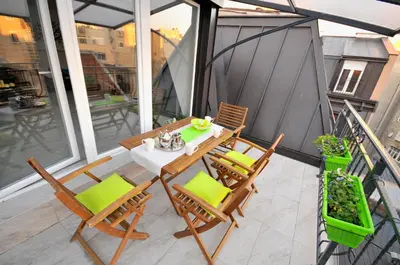 a patio with a table and chairs on a balcony at Apartment Sovica in Belgrade
