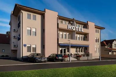 a hotel with two cars parked in front of it at Airport Hotel Garni in Belgrade