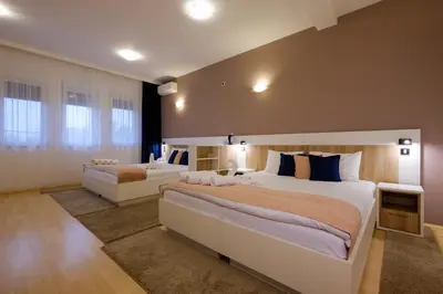 a large bedroom with two beds in a room at Airport Hotel Garni in Belgrade