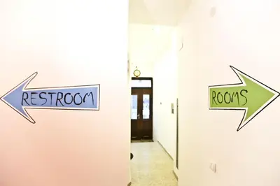two signs on the wall of a hallway with arrows at Hostel 1910 in Belgrade