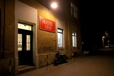 a moped parked outside of a hotel at night at Hostel 1910 in Belgrade