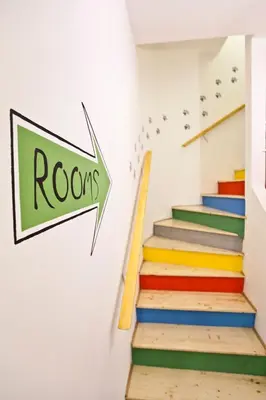 a set of colorful stairs with a sign that reads roos at Hostel 1910 in Belgrade