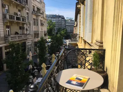 a table on a balcony with a view of a street at Lella Apartment - Pedestrian zone & Charming balcony in Belgrade