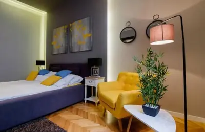 a bedroom with a bed and a yellow couch at Lella Apartment - Pedestrian zone & Charming balcony in Belgrade