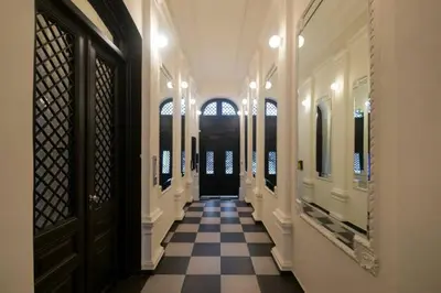 a hallway with a black door and a checkered floor at Lella Apartment - Pedestrian zone & Charming balcony in Belgrade