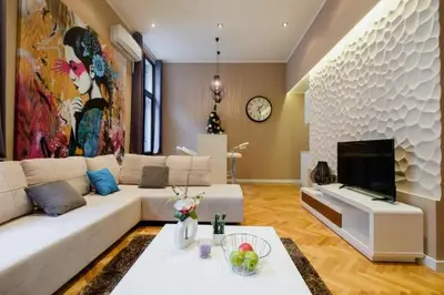 a living room with a white couch and a tv at Lella Apartment - Pedestrian zone & Charming balcony in Belgrade