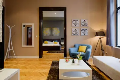 a living room with a blue chair and a couch at Lella Apartment - Pedestrian zone & Charming balcony in Belgrade