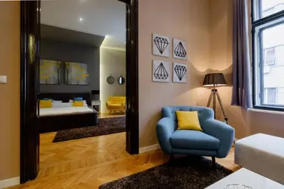 a bedroom with a mirror and a blue chair and a bed at Lella Apartment - Pedestrian zone & Charming balcony in Belgrade
