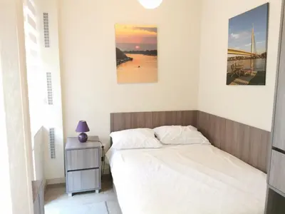 a bedroom with a bed and a nightstand and two pictures at 1A Moment Apartment in Belgrade