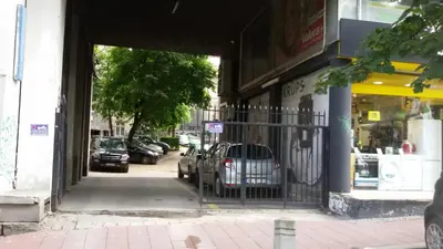 an entrance to a store with cars parked in a parking lot at 1A Moment Apartment in Belgrade