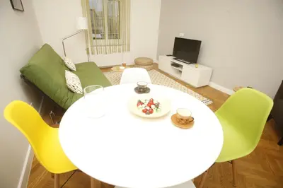 a living room with a white table and yellow chairs at TRAMVAJ Apartments in Belgrade
